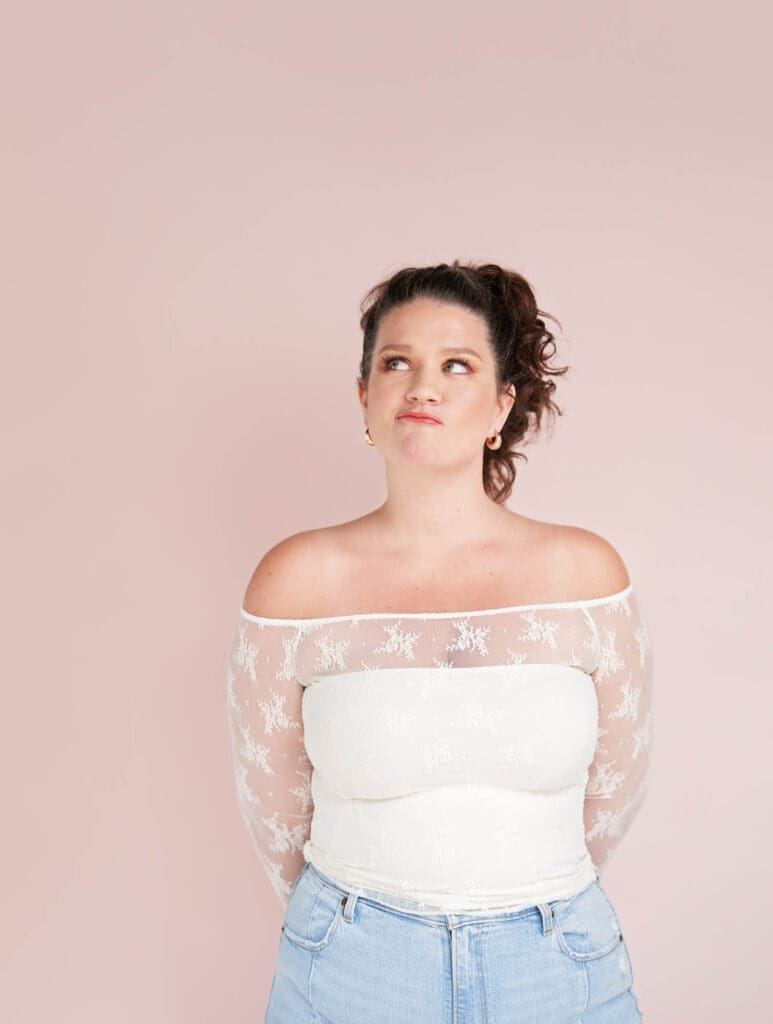 authority-building brand photos for social media selling with taylor lee in white lace and jeans on pink background